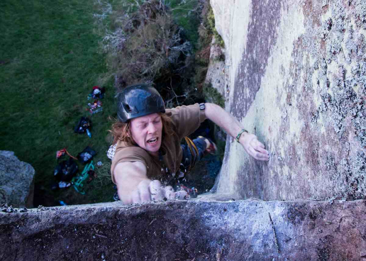 A climber jumps for a chalky hold in a corner