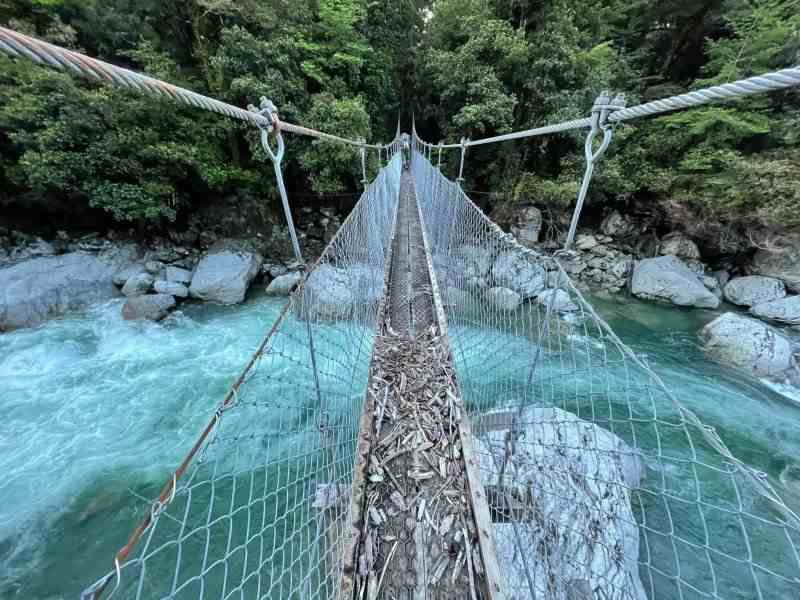 Person in the distance, walking across a wire bridge.