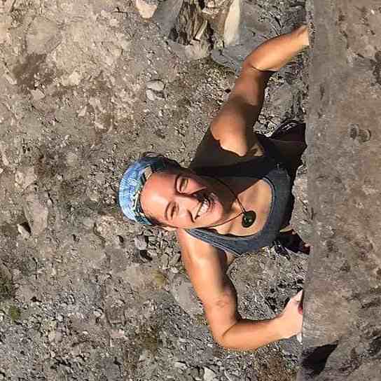 Smiling female climber in tank top and blue bandana from above