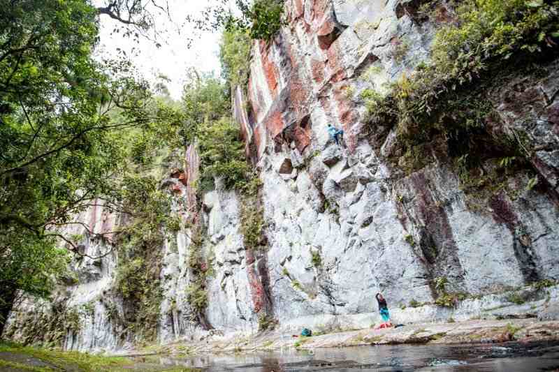 Cliff at the Mangorewa Gorge from a distance with two climbers.