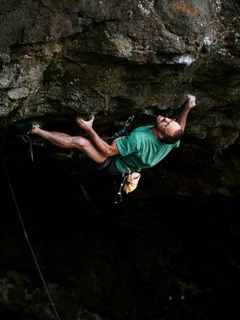 Climber in blue on steeply overhanging rock