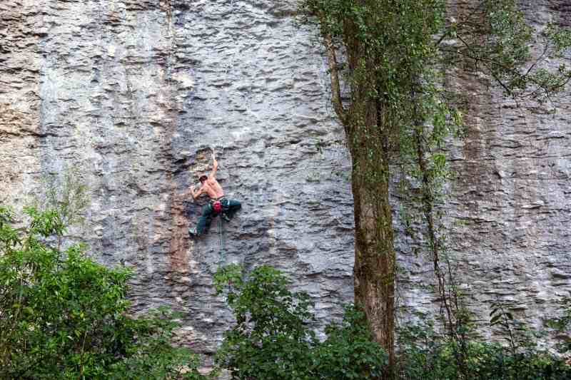 Climber on grey vertical rock